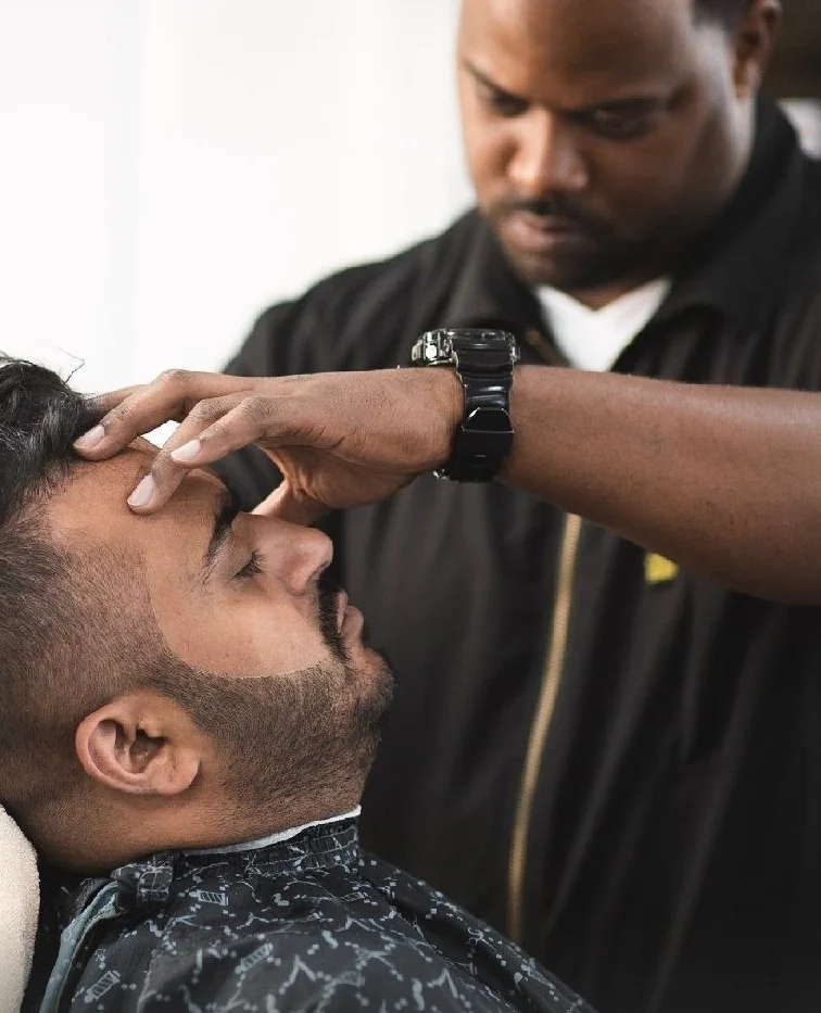 Johnnie J cutting a client in his River North barber studio